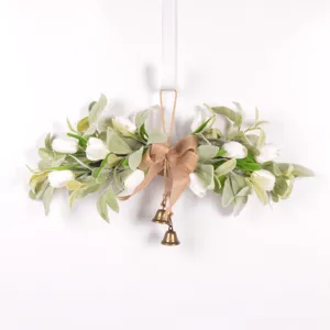 Detalle de guirlande floral de tulipanes artificiales con lazo de yute y campanas de bronce.
