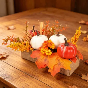Autumn artificial pumpkin and maple leaf centerpiece detail showcasing festive table decor elements.