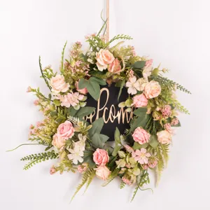 Detailed view of artificial rose flower wreath with green leaves and welcome sign decor.