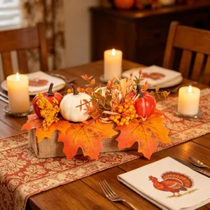 Autumn artificial pumpkin maple leaf centerpiece table decor with burlap base and berries.