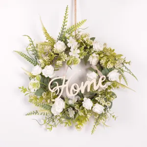 Detailed view of the artificial white rose wreath with green leaves and wooden home sign.