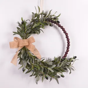 Artificial olive wreath detail with wooden beads and burlap bow for home decoration.