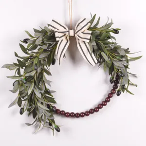 Artificial olive leaf wreath detail showing wooden beads and rustic striped bow decor.