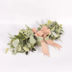 Guirnalda de ramas de olivo artificial con lazo rosa, ideal para la decoración de pared.