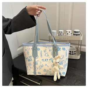 Grande borsa a tracolla in tela con stampa graffiti blu e grazioso ciondolo a forma di coniglietto.