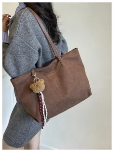 Stylish large capacity suede tote bag for women, commuter shoulder bag with cute bear charm.