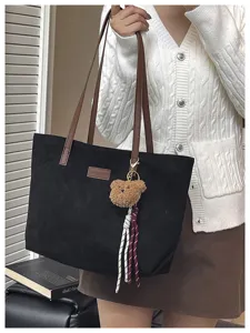 Large black tote bag for women, stylish shoulder handbag with cute bear charm for daily use.