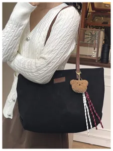 Large capacity black tote handbag featuring cute bear charm and strap for daily commuting use.