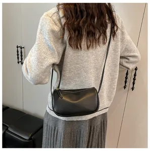 Detailansicht einer schicken schwarzen Umhängetasche mit Kontrastnähten im Alltagsoutfit.
