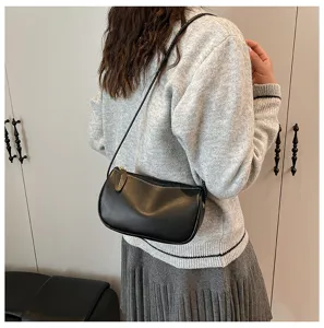 Detailaufnahme einer eleganten schwarzen Schultertasche am Model für den modernen Look.