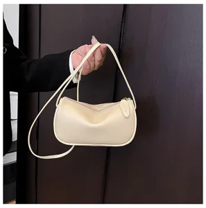 Detailansicht einer modischen hellgelben Schultertasche mit klassischer Beutelform.