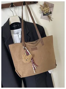 Spacious brown suede tote bag for women, stylish commuting casual shoulder bag with cute bear charm.