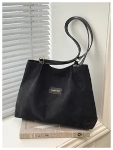 Vista dettagliata della borsa tote nera retrò, con grande capacità e stile minimalista.