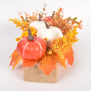 Autumn artificial pumpkin maple leaf decor table centerpiece with berries and burlap base.