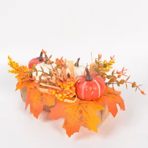 Autumn artificial pumpkin maple leaf decor detail shot with burlap base and colorful berries.