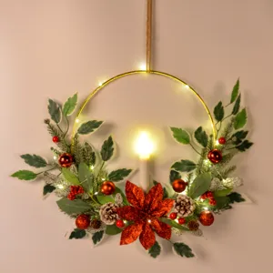 Christmas wreath detail shot showing gold hoop, candle, pine needles, and red decorative berries.