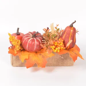 Autumn artificial pumpkin maple leaf centerpiece decoration with burlap base for Thanksgiving.