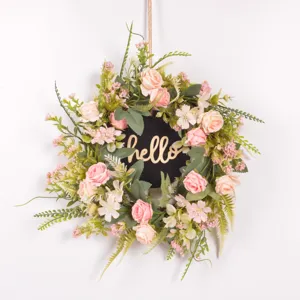 Artificial rose floral wreath detail, pink flower and green leaf door hanging wall decor.