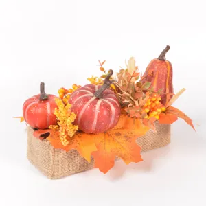 Detailed close-up of autumn artificial pumpkins and maple leaves decoration for seasonal display.