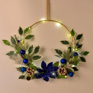Christmas wreath decoration with blue flowers pine cones and fairy lights for holiday home decor