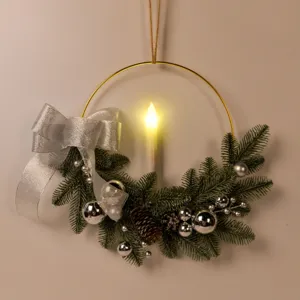 Detailed close-up view of Christmas candle wreath with gold iron ring and warm LED light.