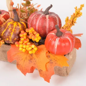 Autumn artificial pumpkin maple leaf decoration detail featuring vibrant berries and burlap base.
