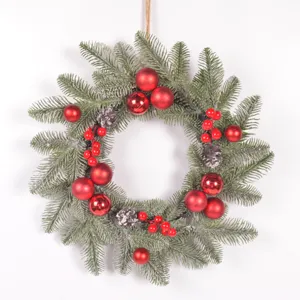 Christmas wreath detail view featuring pine needles, red baubles, and decorative berries.