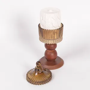 Portacandele vintage in vetro ambrato con base in legno e coperchio per arredamento.