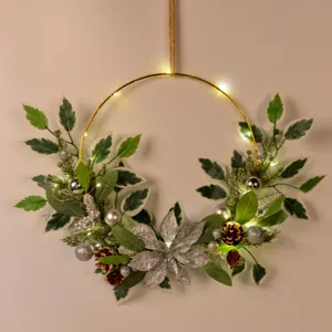 Christmas wreath wall hanging with gold metal hoop artificial leaves pinecones and LED lights
