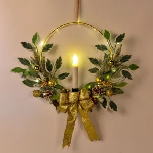 Couronne de Noël décorative avec bougie LED anneau doré nœud et pomme de pin pour déco de maison.
