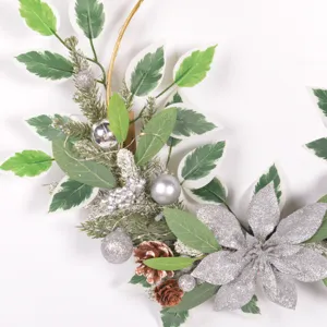 Christmas decorative wreath detail with artificial leaves pinecones and silver poinsettia.