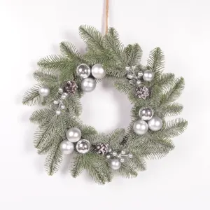 Detailed view of the Christmas wreath with frosted pine needles, silver baubles and pinecones.