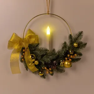 Christmas candlestick wreath detail featuring gold iron ring pine needles bow and LED candle