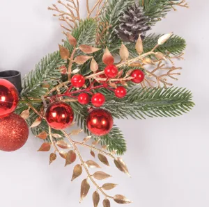 Nahaufnahme des Weihnachtskranzes mit Tannenzweigen, roten Beeren und goldenen Blättern.