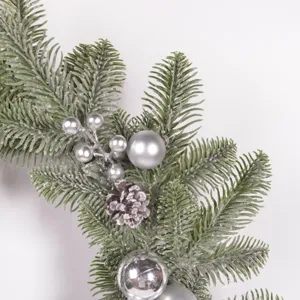 Detail of Christmas artificial pine needle wreath with silver balls and pinecones decoration