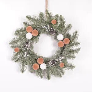 Detailed view of artificial Christmas wreath with pine needles, velvet balls, and pinecones.