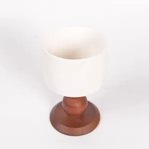 Vista dettagliata del corpo della tazza in ceramica e della base in legno per arredamento.