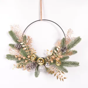 Detailansicht des weihnachtlichen Dekokranzes mit Tannennadeln, Zapfen und Goldkugeln.