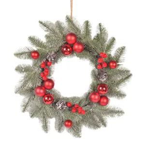 Christmas wreath with red balls, pine cones and artificial pine needles for front door decor.
