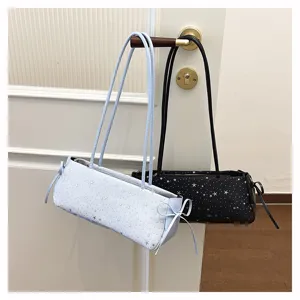 Detailed view of stylish horizontal shoulder bags featuring star patterns and side bow tie designs.