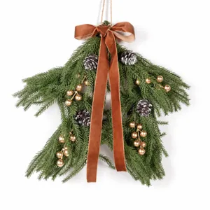 Christmas star rattan wall hanging with pine cones, berries and bow for holiday home decor.