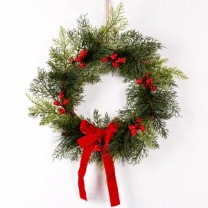 Christmas pine wreath with red berries and velvet bow for holiday door and wall decoration 40cm