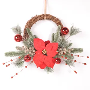 Close-up detail of Christmas wreath with red poinsettia, frosted pine branches and berries.
