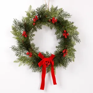 Christmas pine wreath with red berries and velvet bow for holiday door wall hanging decor.