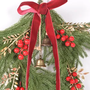 Christmas red velvet bow decorative pine branch detail closeup for holiday home decor display.