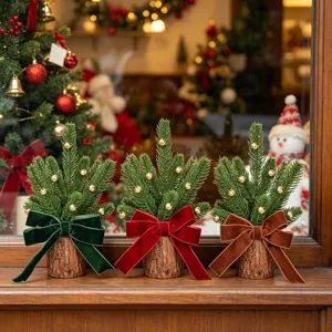 Mini Christmas tree detail view with cute velvet bows and gold bells on wood stands.