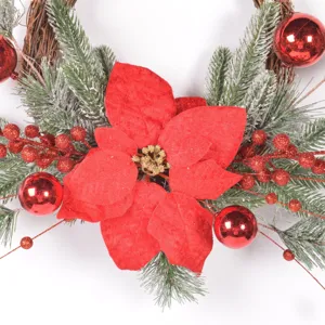 Christmas rattan wreath with artificial poinsettia pine branches and red berries detail.