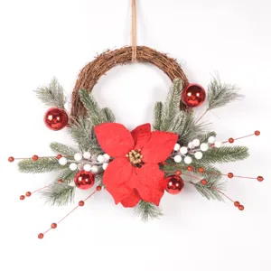 Christmas rattan wreath closeup featuring artificial pine branches, red poinsettia and berries.