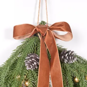 Christmas hanging decor detail close-up showing pine branches, pinecones and velvet bow.