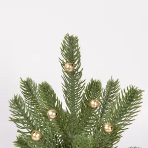 Close-up detail shot of artificial Christmas tree branch decorated with cute mini gold bells.
